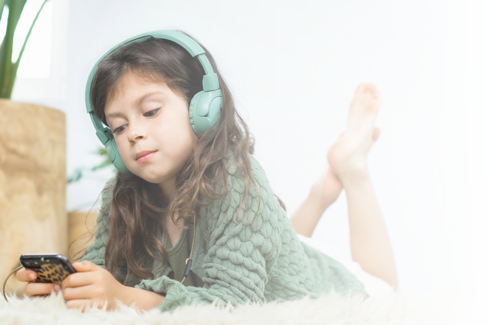 Relaxed girl watching a phone with POGS headphones 