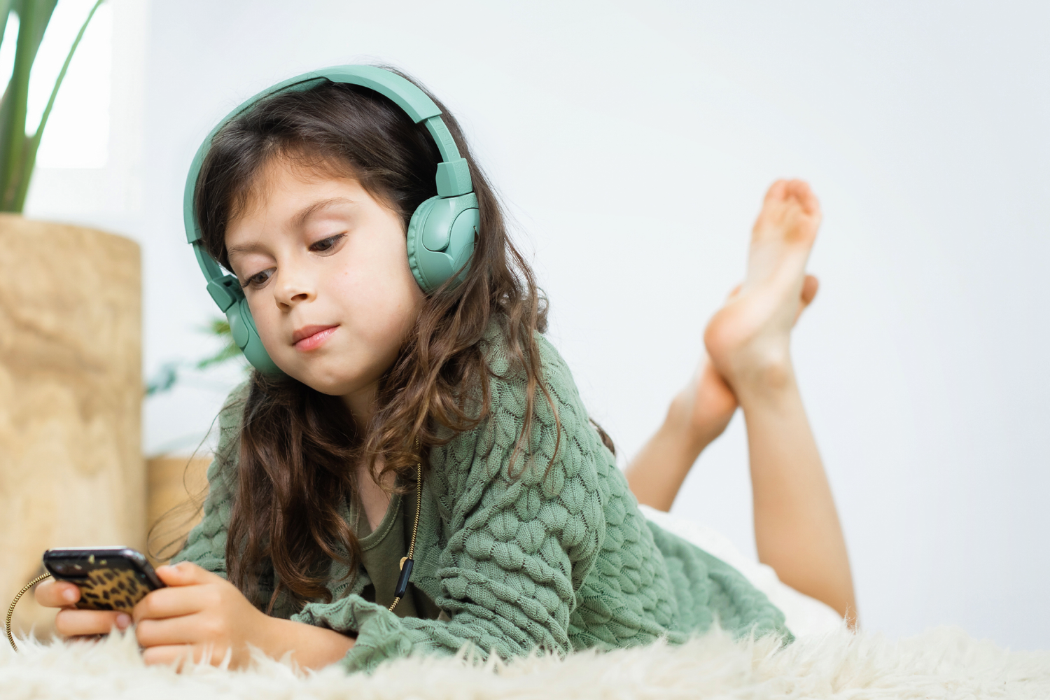 Relaxed girl watching a phone with POGS headphones