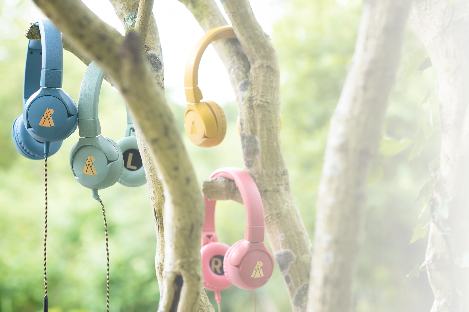 POGS headphones of different colors hanging in a tree