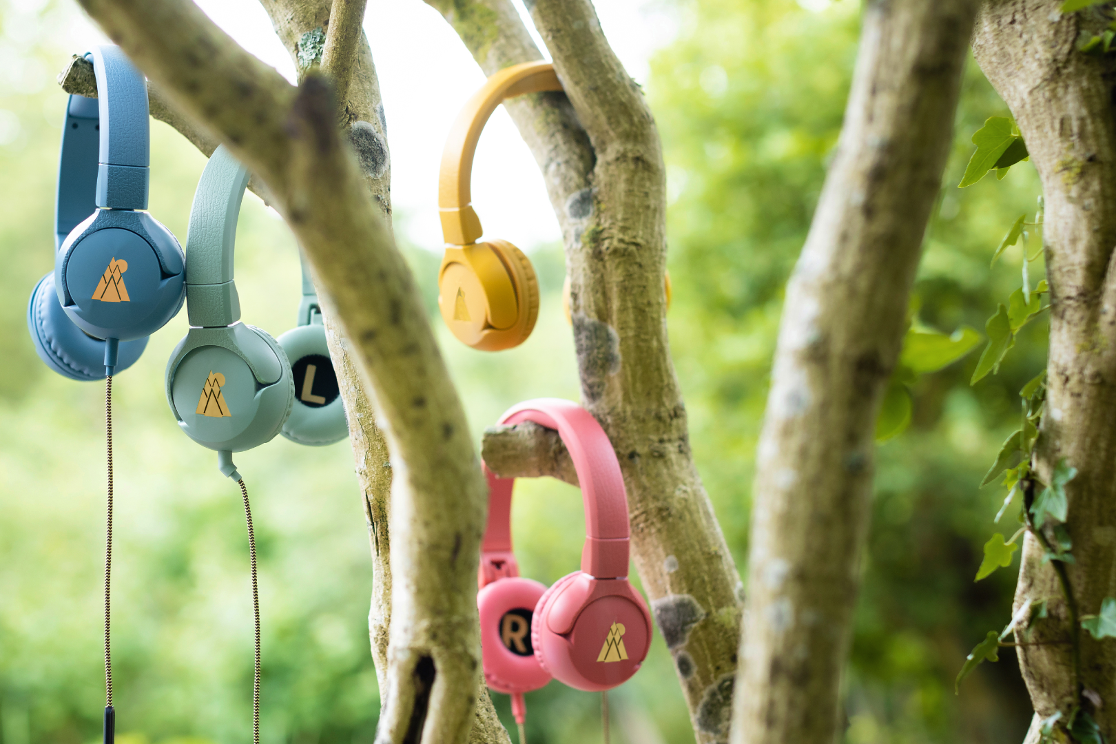 POGS headphones of different colors hanging in a tree